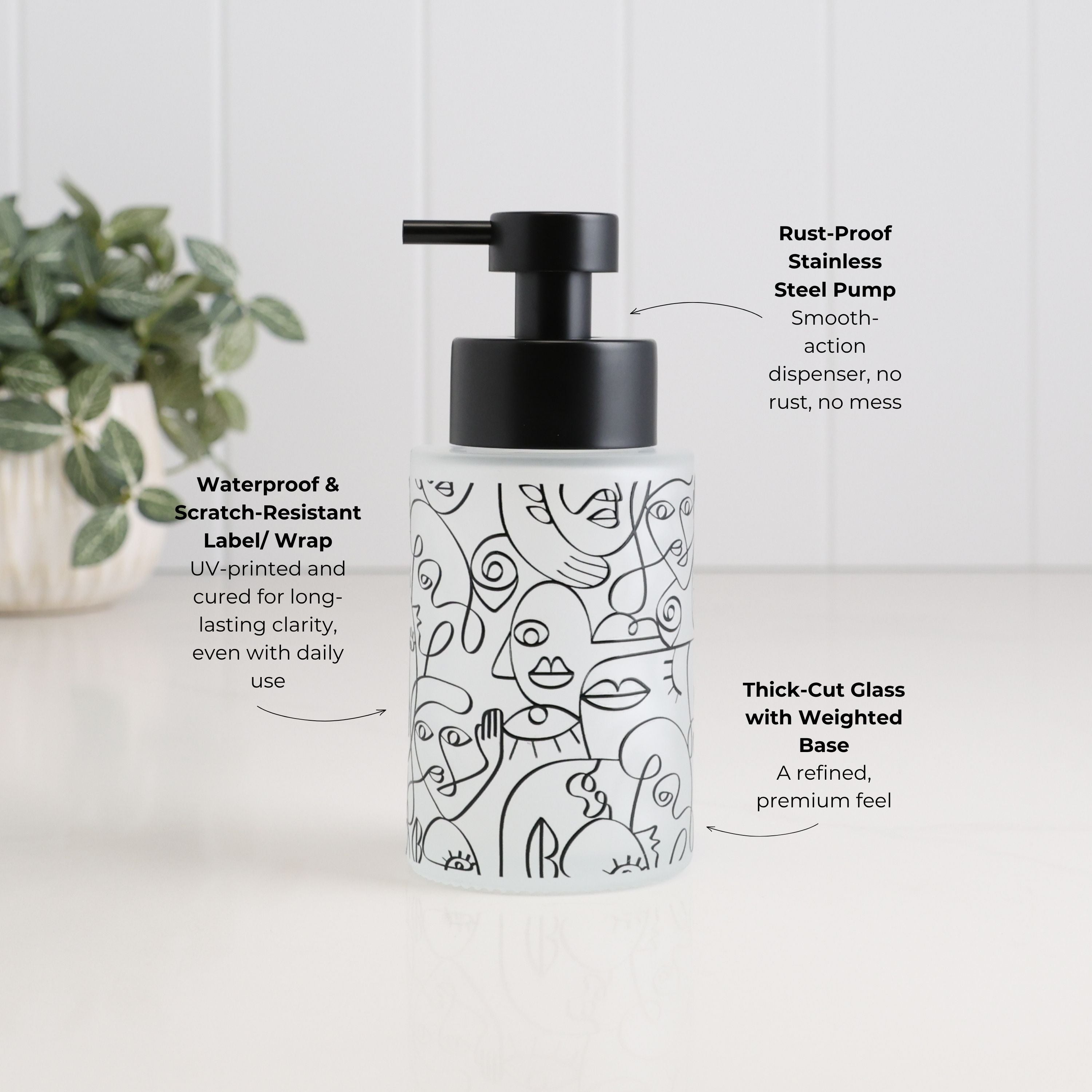250ml frosted glass soap dispenser with black abstract face design, satin black stainless steel pump, waterproof scratch-resistant wrap and thick-cut weighted glass base, designed as a refillable hand soap or lotion dispenser.