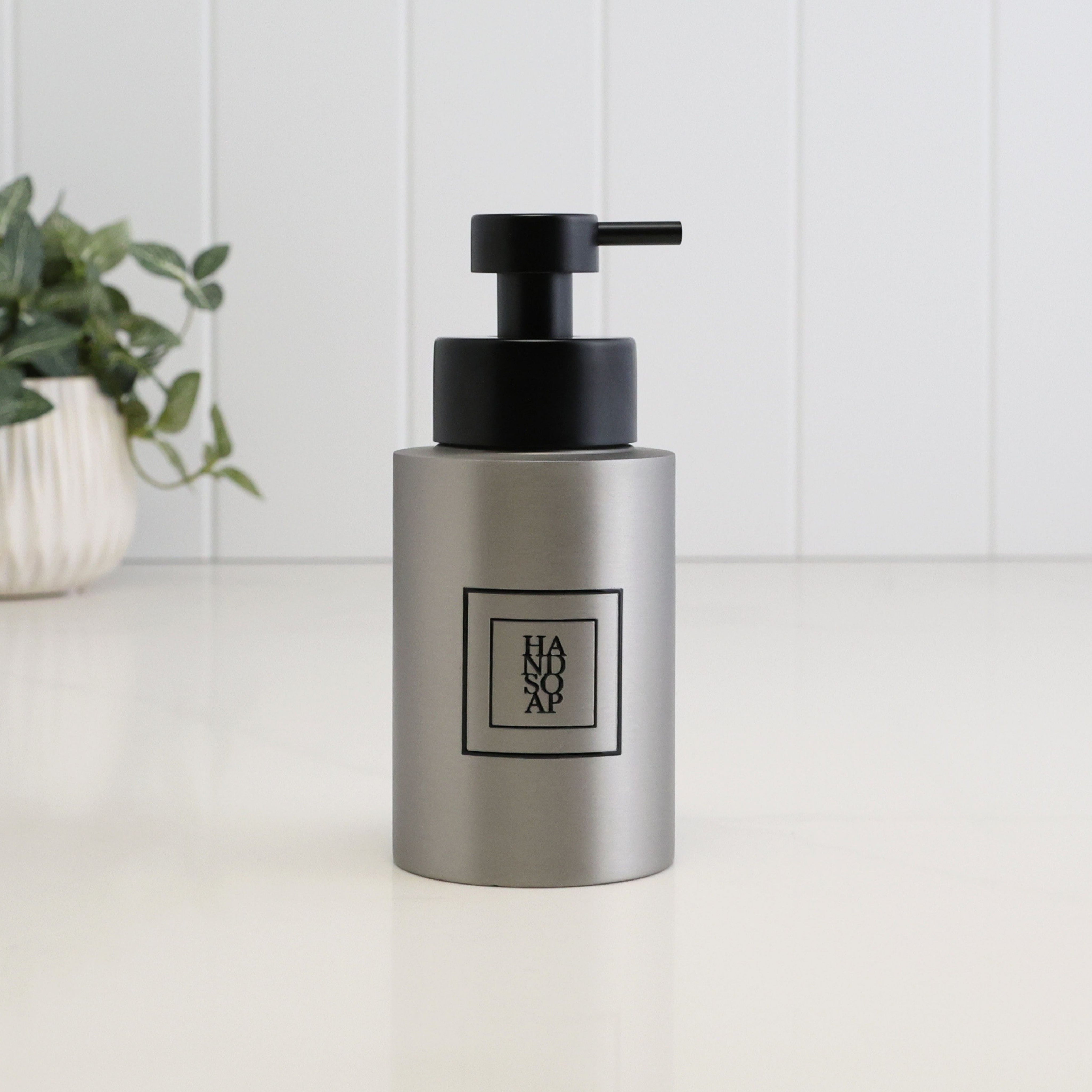 250ml refillable hand soap dispenser in brushed 304 stainless steel with a black square Hand Soap label and satin black liquid pump, designed for a modern bathroom, cloakroom or kitchen sink.