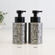 Front and back view of a 250ml brushed 304 stainless steel soap dispenser with black abstract face line art, satin black liquid pump and subtle Loopa branding on the reverse.
