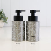 Front and back view of a 250ml brushed 304 stainless steel soap dispenser with white abstract line art, satin black liquid pump and Loopa branding, showing the decorative wrap around the refillable bottle.