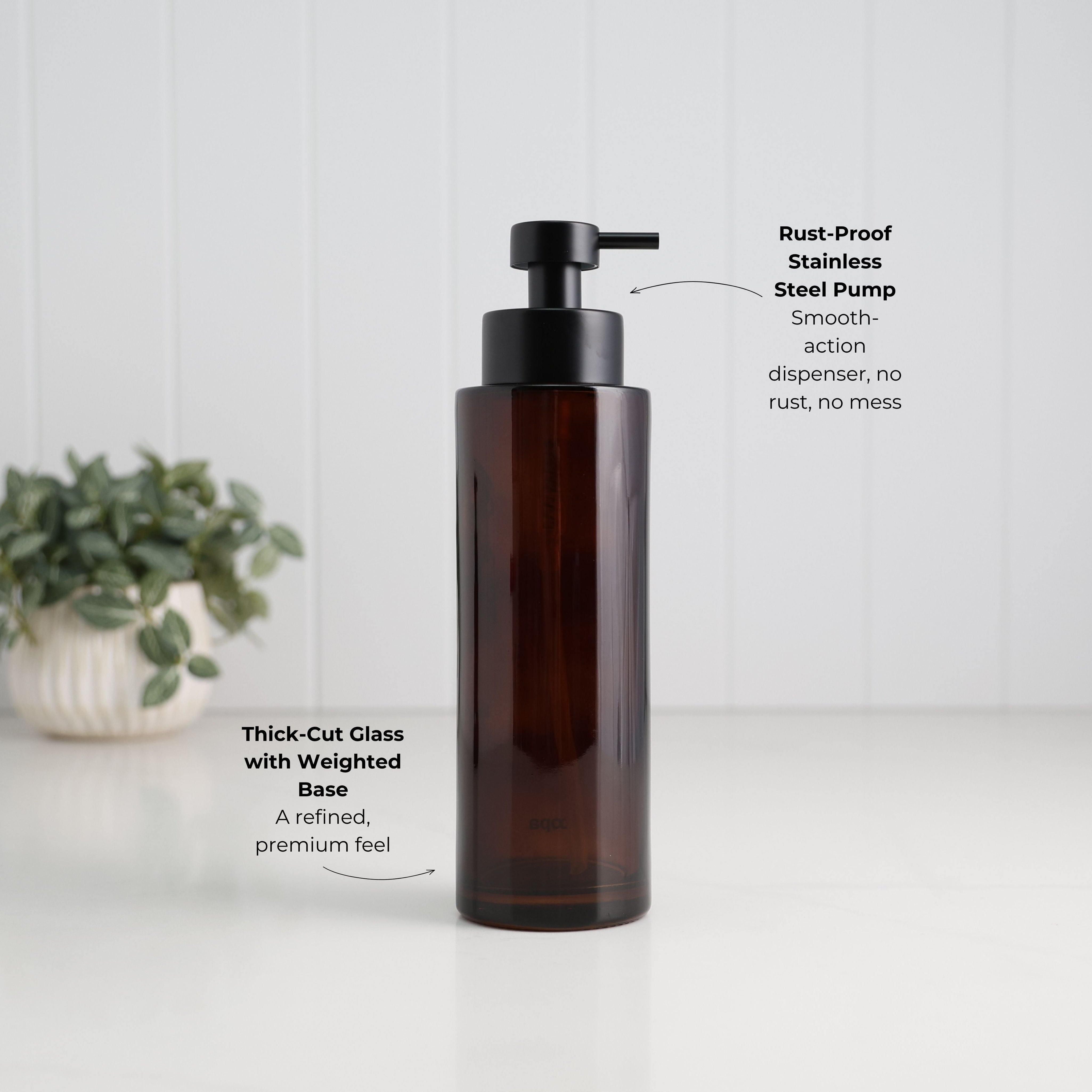 500ml amber glass refillable soap dispenser with a thick-cut weighted base and satin black stainless steel liquid pump, highlighting the durable glass construction and premium bathroom or kitchen design.