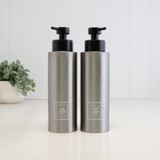 Pair of 500ml brushed 304 stainless steel shower dispensers with white square Shampoo and Conditioner labels, finished with satin black liquid pumps for a coordinated bathroom set.
