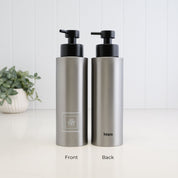 Front and back view of a 500ml brushed 304 stainless steel shampoo dispenser with white square Shampoo label, Loopa branding and satin black liquid pump.