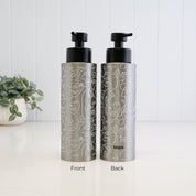 Front and back view of a 500ml brushed 304 stainless steel soap dispenser with white abstract face line art, satin black liquid pump and Loopa branding, showing the decorative wrap around the refillable bottle.