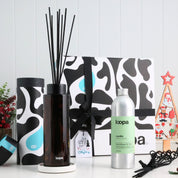 Amber glass diffuser Christmas gift box with black reeds, natural refill oil and premium packaging, styled among festive decorations. Perfect eco-friendly holiday home fragrance gift for loved ones and seasonal home styling.