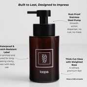 Amber glass round bottle dispenser with a white square label featuring arrow artwork, designed for refillable soap or lotion use