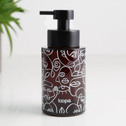 Amber glass round bottle dispenser with a white wrap label, shown as a 250ml refillable option for soap or lotion use