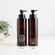 Two amber glass pump bottles shown side by side on a white surface against a white paneled wall, labeled Front and Back. A small potted plant sits on the left.