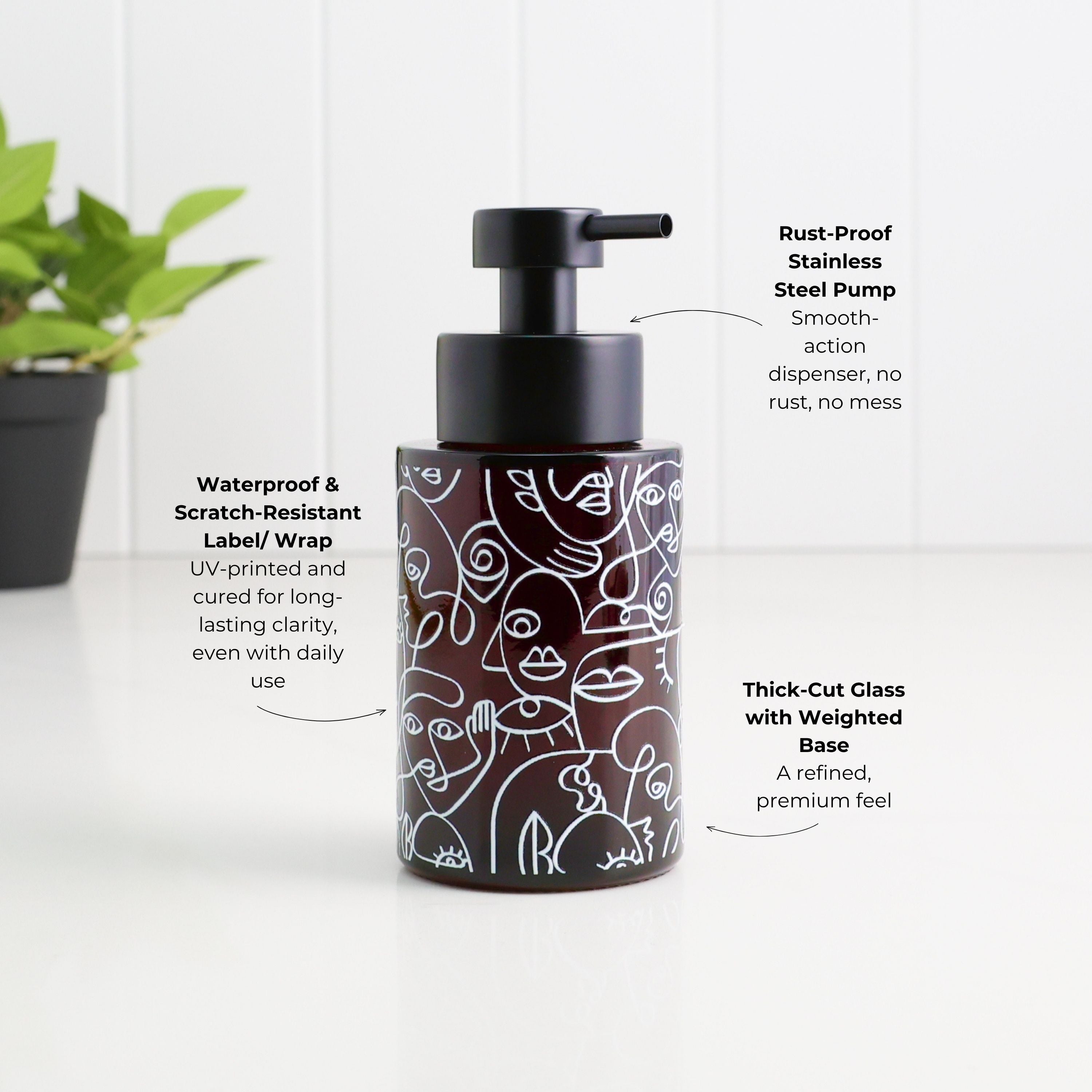 A dark brown cylindrical pump bottle with a black pump dispenser, featuring white line art illustrations of faces. The bottle is shown on a white surface with a white paneled background, with text callouts highlighting its features: 'Rust-Proof Stainless Steel Pump', 'Waterproof & Scratch-Resistant Label/Wrap', and 'Thick-Cut Glass with Weighted Base'.