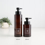 500ml and 250ml amber glass soap dispensers with white square dish soap and hand soap labels and satin black pumps, showing the two refillable bottle sizes side by side.
