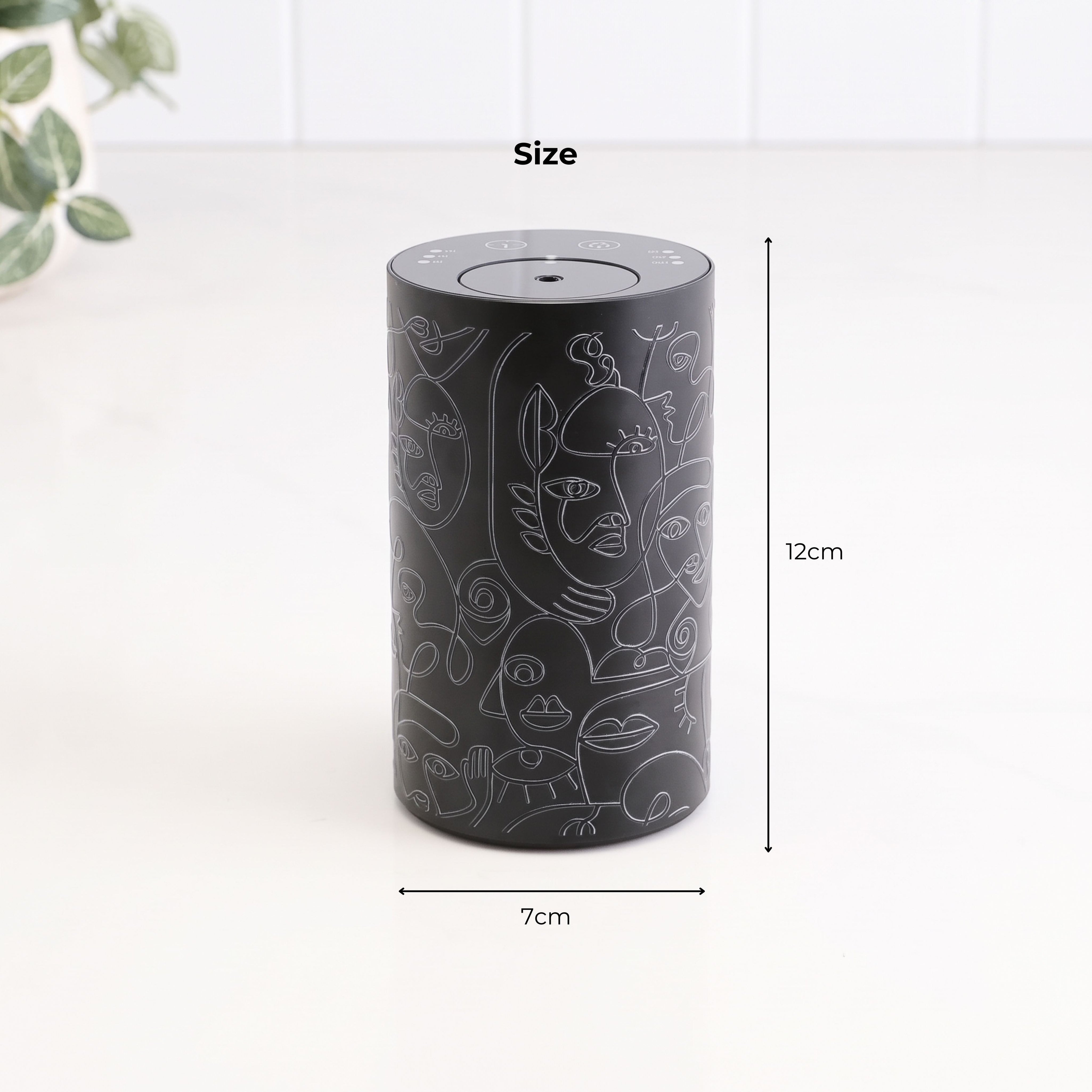 Loopa black cordless waterless essential oil diffuser featuring an abstract line art face pattern and cylindrical metal alloy body. Product dimensions show a compact height of 12cm and diameter of 7cm. Portable rechargeable aromatherapy diffuser designed for use in bedrooms, bathrooms, living rooms, offices and other small spaces.