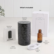 Loopa black cordless waterless essential oil diffuser with abstract line art design, displayed alongside its included accessories. Package contents show the rechargeable metal diffuser, 20ml amber glass essential oil bottle, USB charging cable, spare straw tube, operating instruction manual and white packaging box. Complete aromatherapy diffuser set for home fragrance.