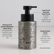 Brushed stainless steel round bottle dispenser with a black wrap featuring arrow artwork, designed for refillable use at kitchen or bathroom sinks