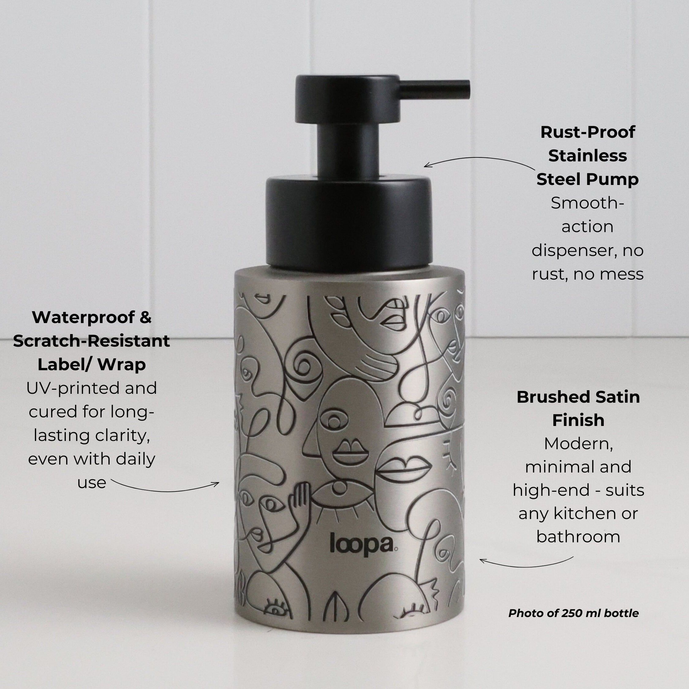 Brushed stainless steel round bottle dispenser with a black wrap featuring arrow artwork, designed for refillable use at kitchen or bathroom sinks