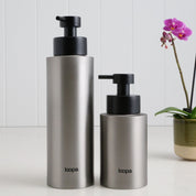 Two brushed stainless steel round bottle dispensers with a plain, unlabelled finish, shown together in 500ml and 250ml sizes for kitchens, bathrooms, or utility spaces