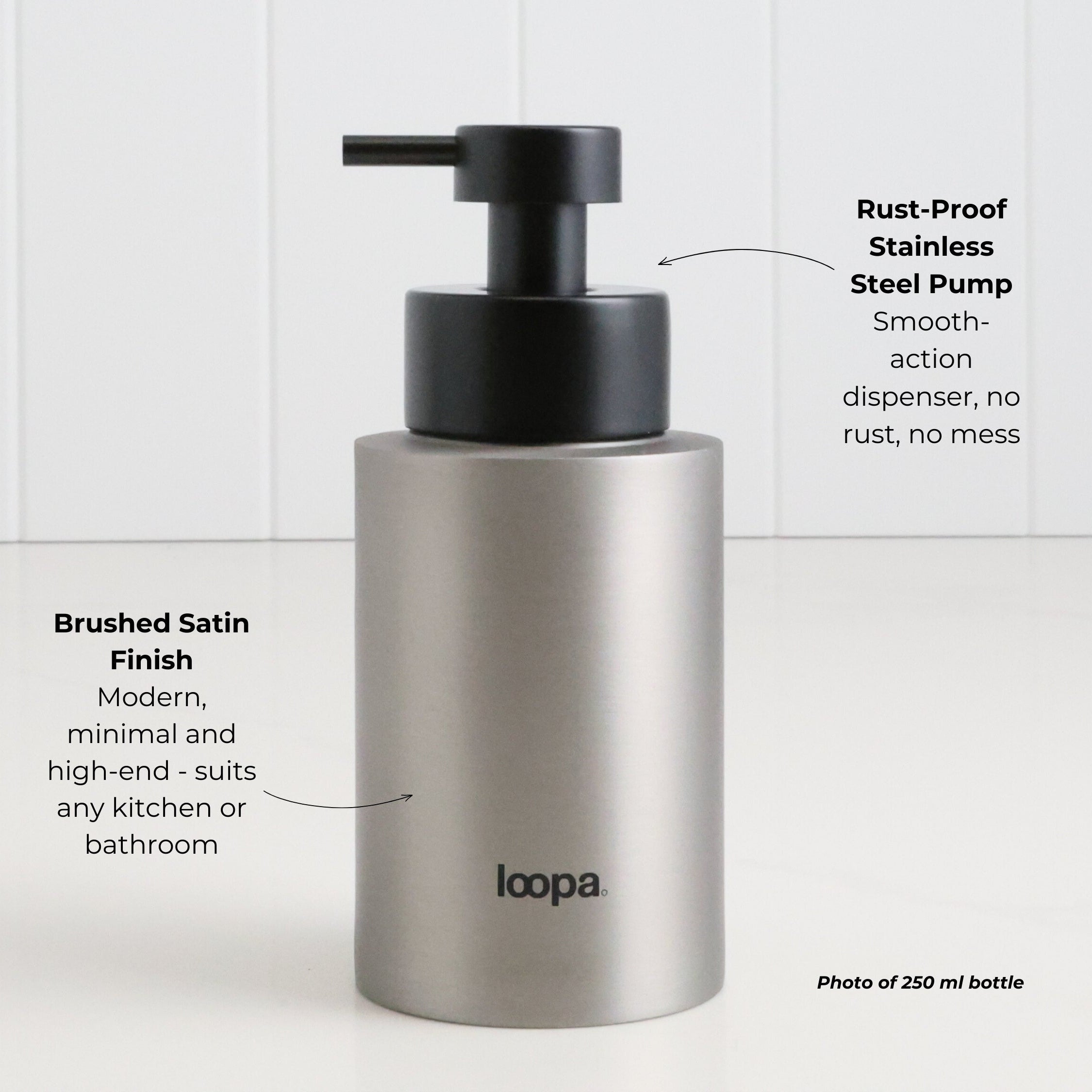 Brushed stainless steel round bottle dispenser with subtle arrow detailing and a plain finish, shown as a 250ml refillable bottle for kitchen, bathroom, or WC use