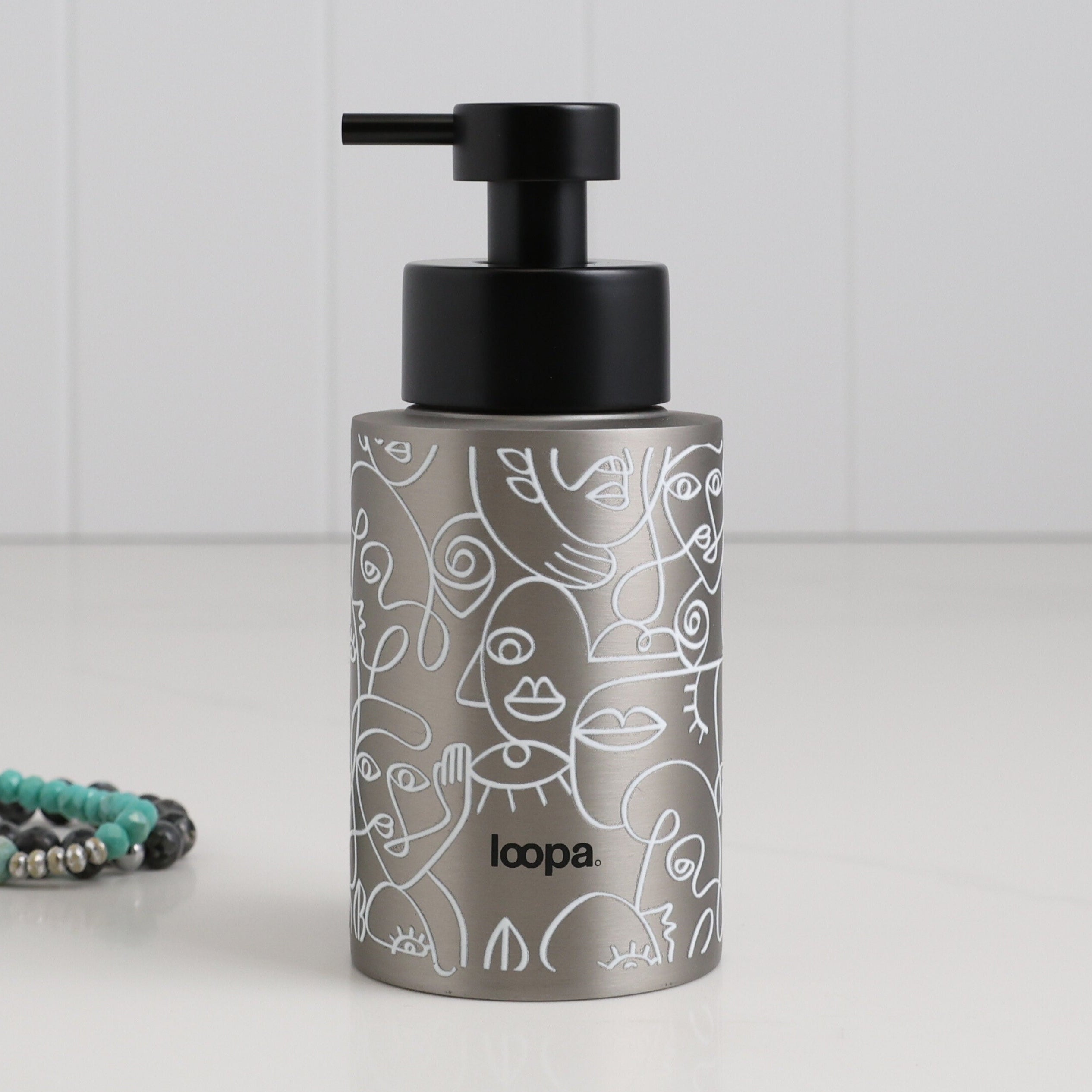 Brushed stainless steel round bottle dispenser with a white wrap label, shown as a 250ml refillable option for soap or lotion