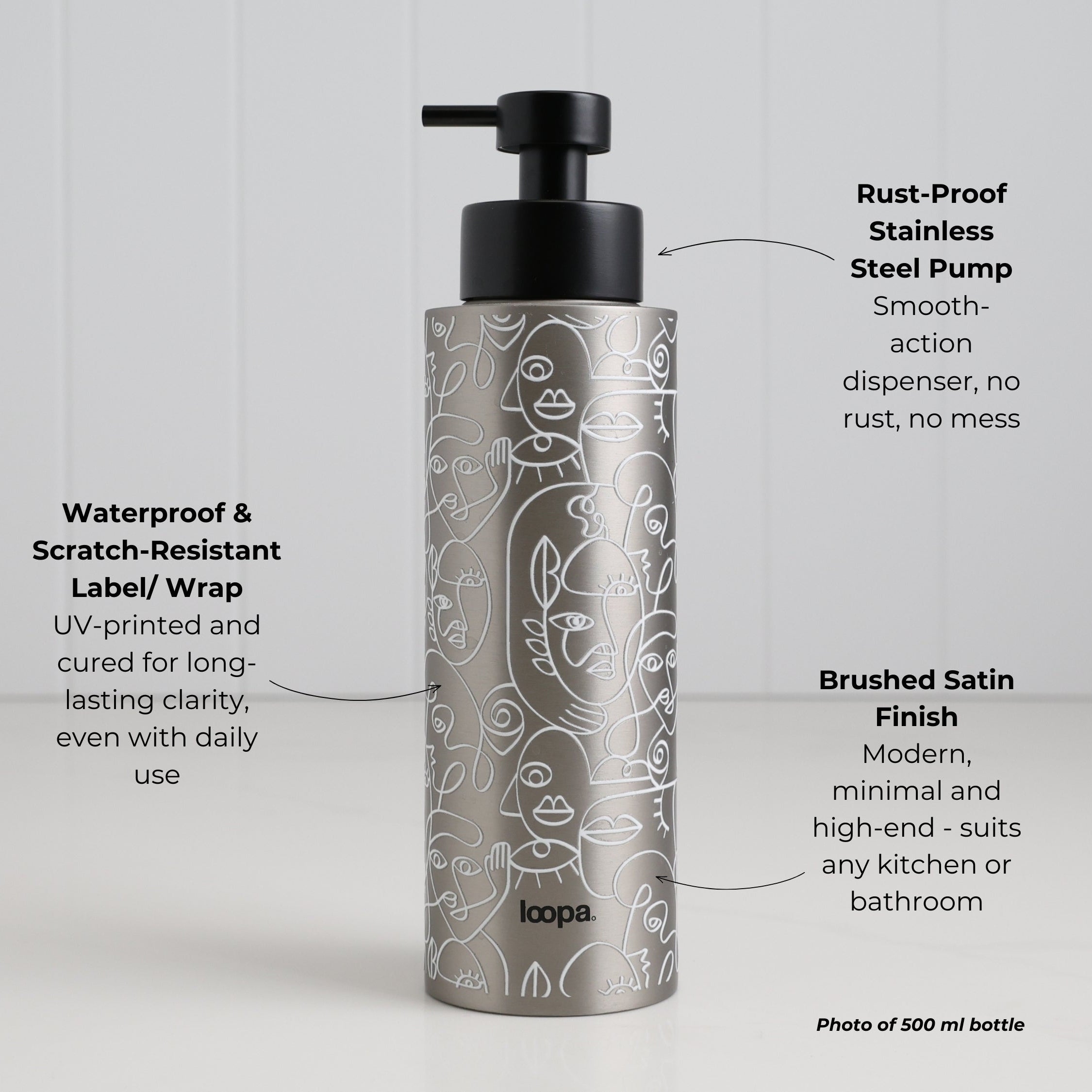Brushed stainless steel round bottle dispenser with a white wrap and arrow artwork, shown as a 500ml refillable option for soap or lotion