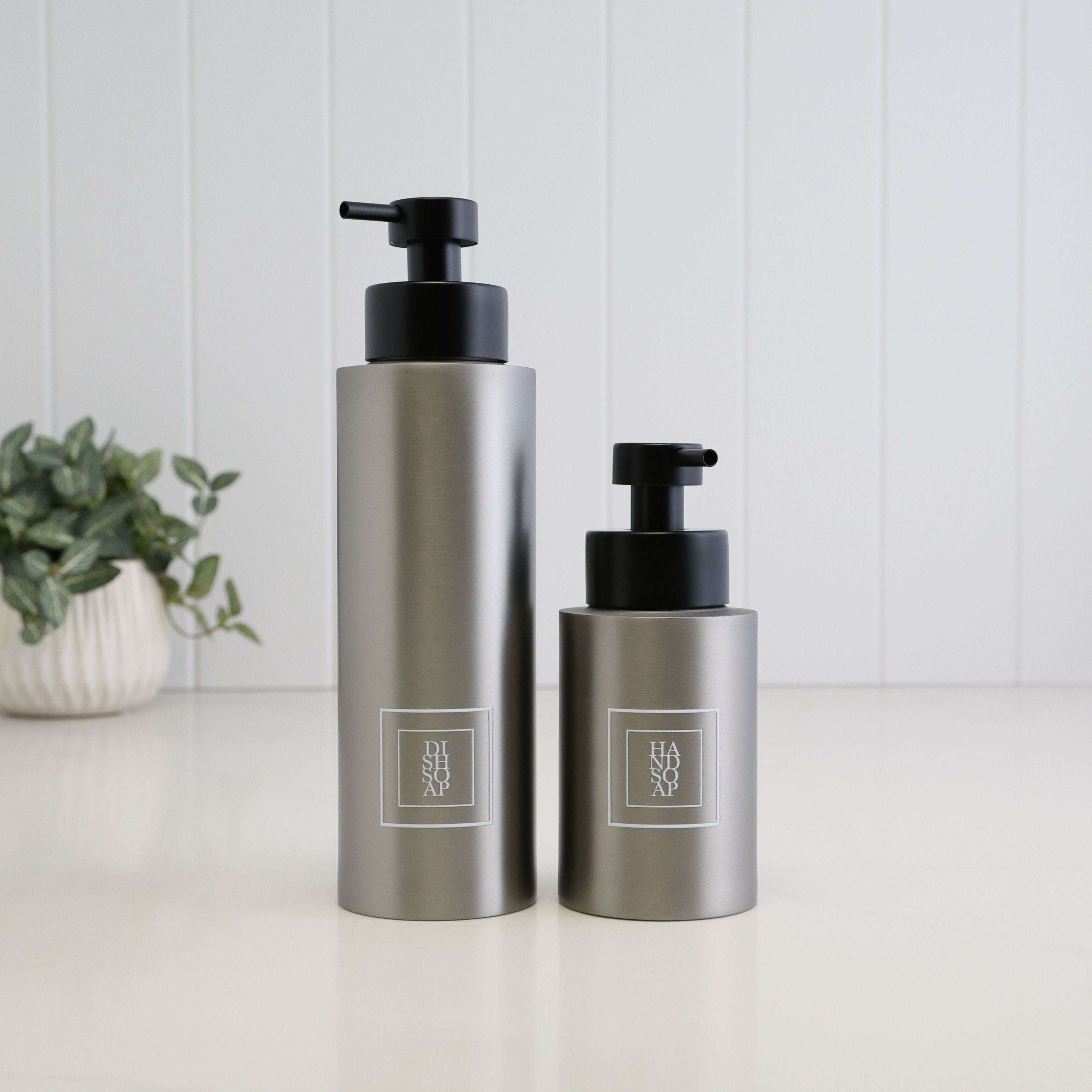 250ml and 500ml brushed 304 stainless steel soap dispensers with white square Hand Soap and Dish Soap labels and satin black liquid pumps, shown together on a clean white surface.