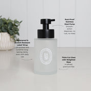 Frosted glass hand soap dispenser with white oval label, satin black stainless steel liquid pump, weighted thick-cut glass base and waterproof scratch-resistant UV-DTF design.