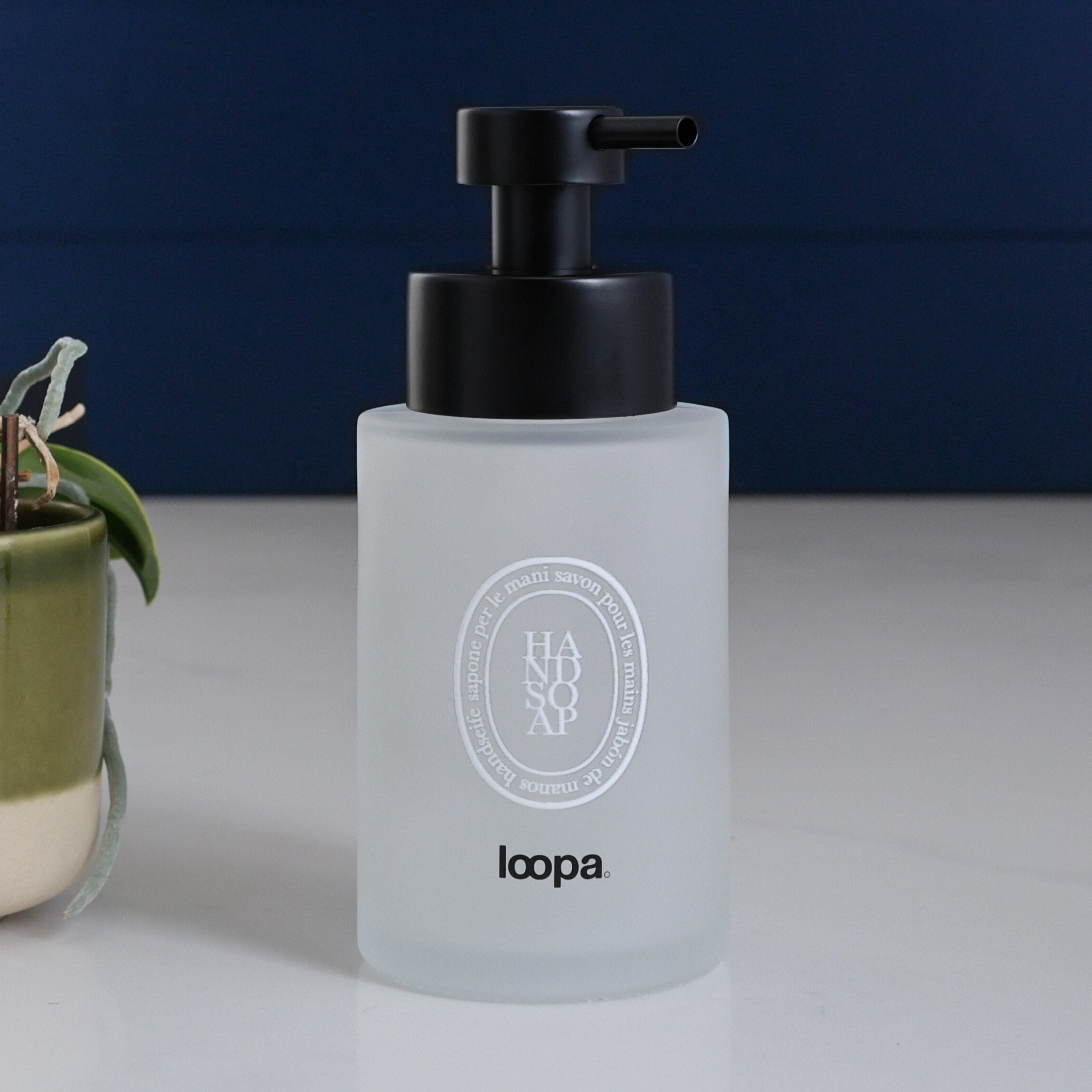 Frosted glass round bottle dispenser with a white oval label, shown as a 250ml refillable option for soap or lotion