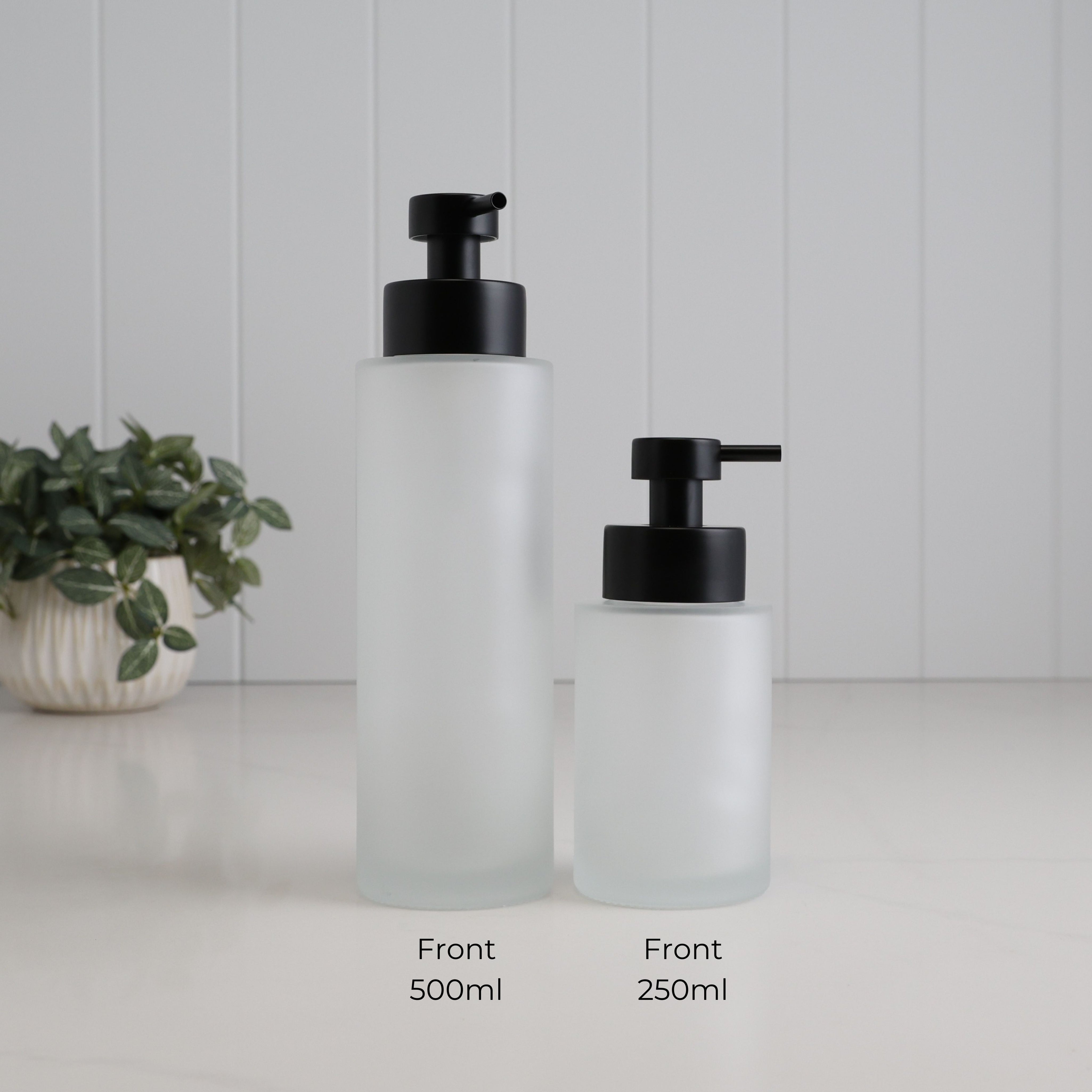 Front view of 500ml and 250ml frosted glass refillable soap dispensers side by side, showing the difference in bottle size with matching satin black liquid pumps.