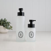 250ml and 500ml frosted glass soap dispensers with black oval hand soap and dish soap labels, finished with satin black stainless steel liquid pumps.