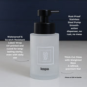 Square frosted glass bottle dispenser featuring a white label with arrow detailing, designed for refillable soap or lotion in modern spaces