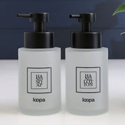 Compact square frosted glass dispenser bottle with a black label, designed for refillable soap or lotion in everyday home use
