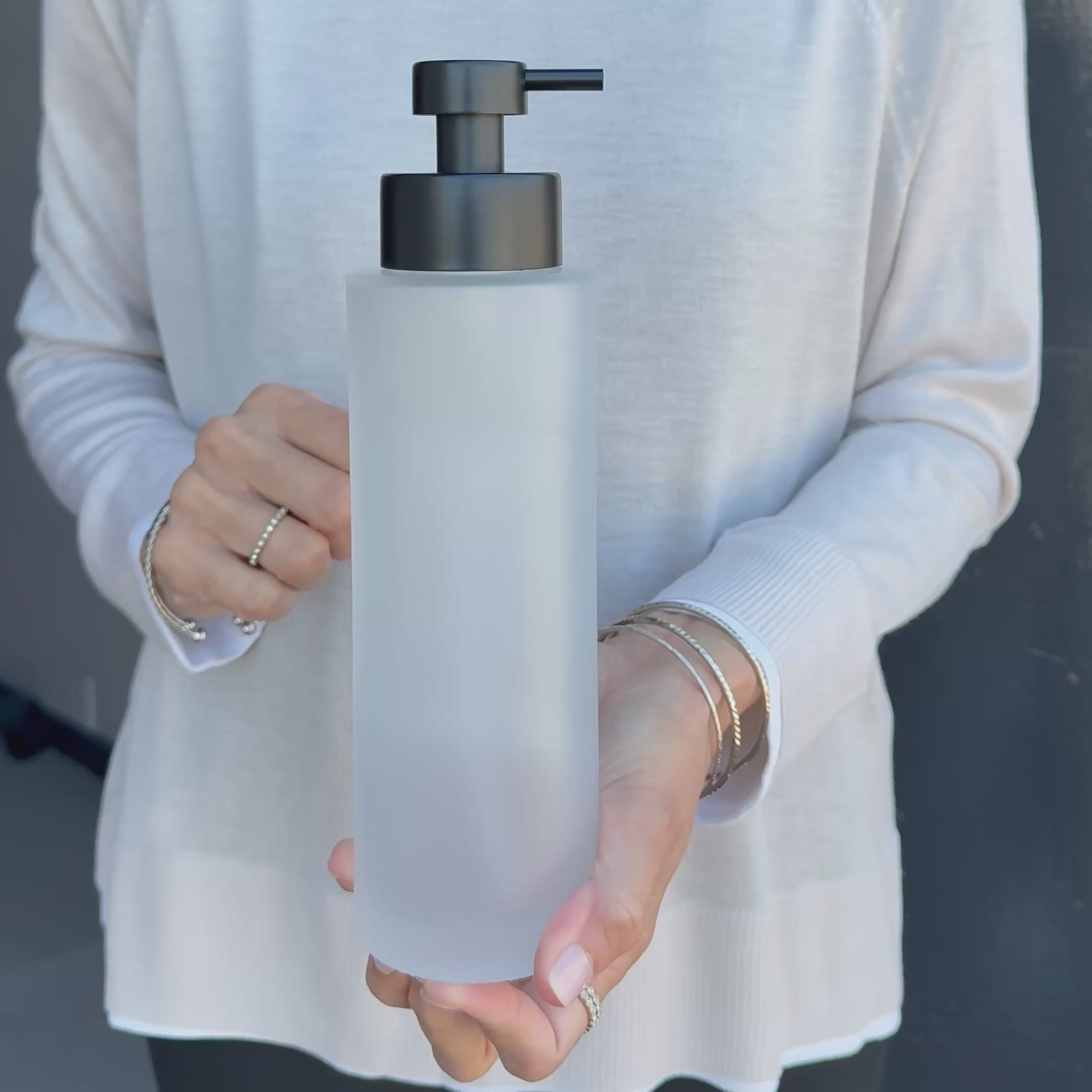 Video showing a 500ml frosted glass refillable soap dispenser held in hand to demonstrate its size, finish and satin black liquid pump.