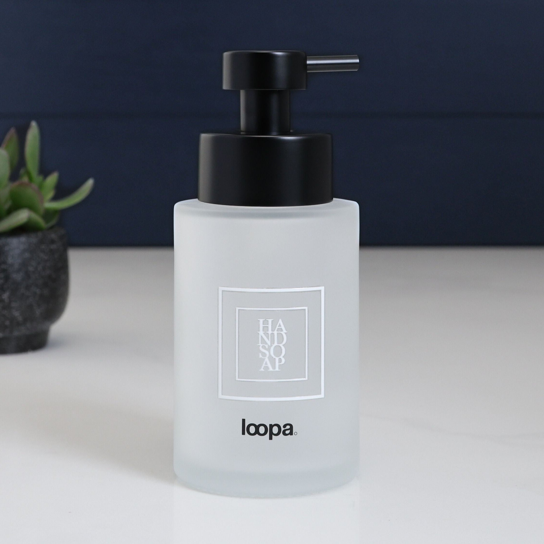 Matte square frosted glass bottle dispenser with a simple white label, designed for refillable everyday soap or lotion use