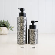 Front and back views of brushed 304 stainless steel soap dispensers in 500ml and 250ml sizes, finished with black abstract face line art, satin black liquid pumps and Loopa branding.