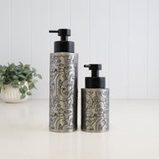250ml and 500ml brushed 304 stainless steel soap dispensers with black abstract line art and satin black pumps, shown together to compare the two refillable bottle sizes.