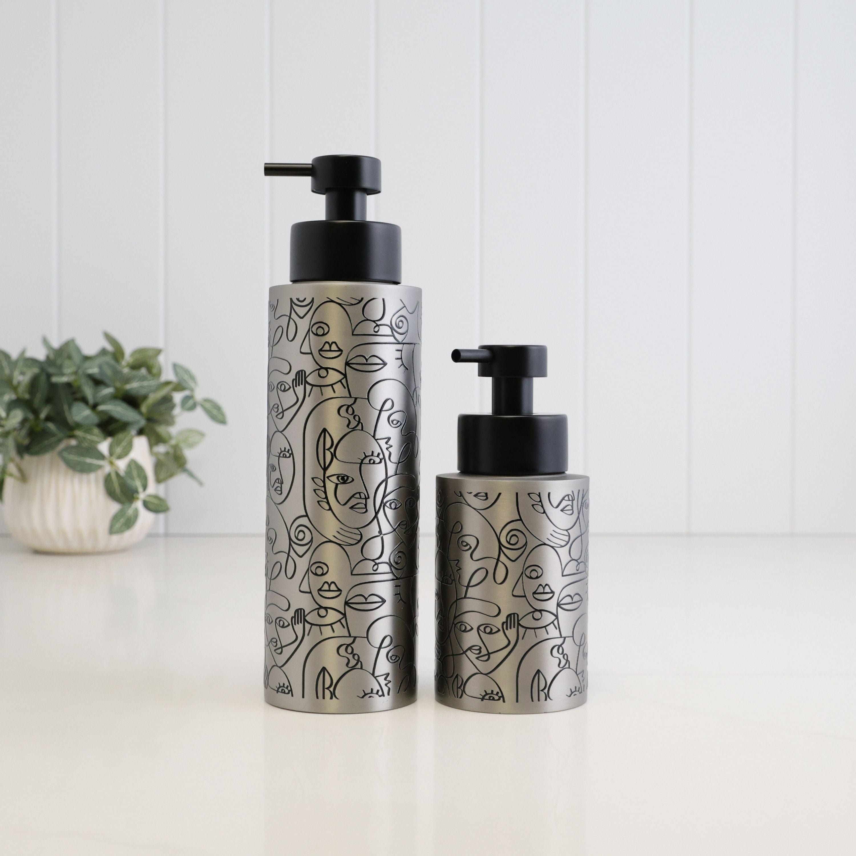250ml and 500ml brushed 304 stainless steel soap dispensers with black abstract line art and satin black pumps, shown together to compare the two refillable bottle sizes.